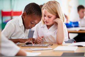 two pupils sitting at a table and discussing work