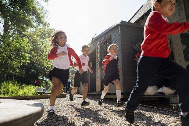 Primary school pupils running outside