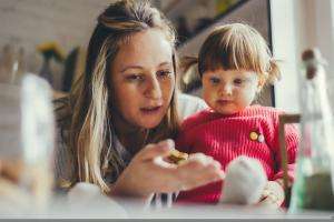 woman showing young child something in her hand